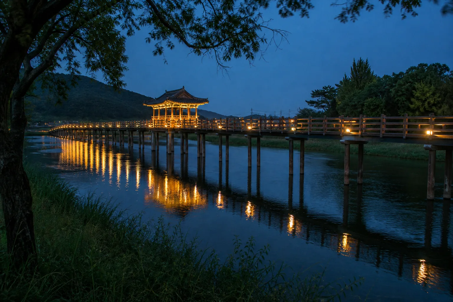 해가 진 뒤 강변 산책로에서 바라본 목재 월영교와 따뜻한 불빛 반영