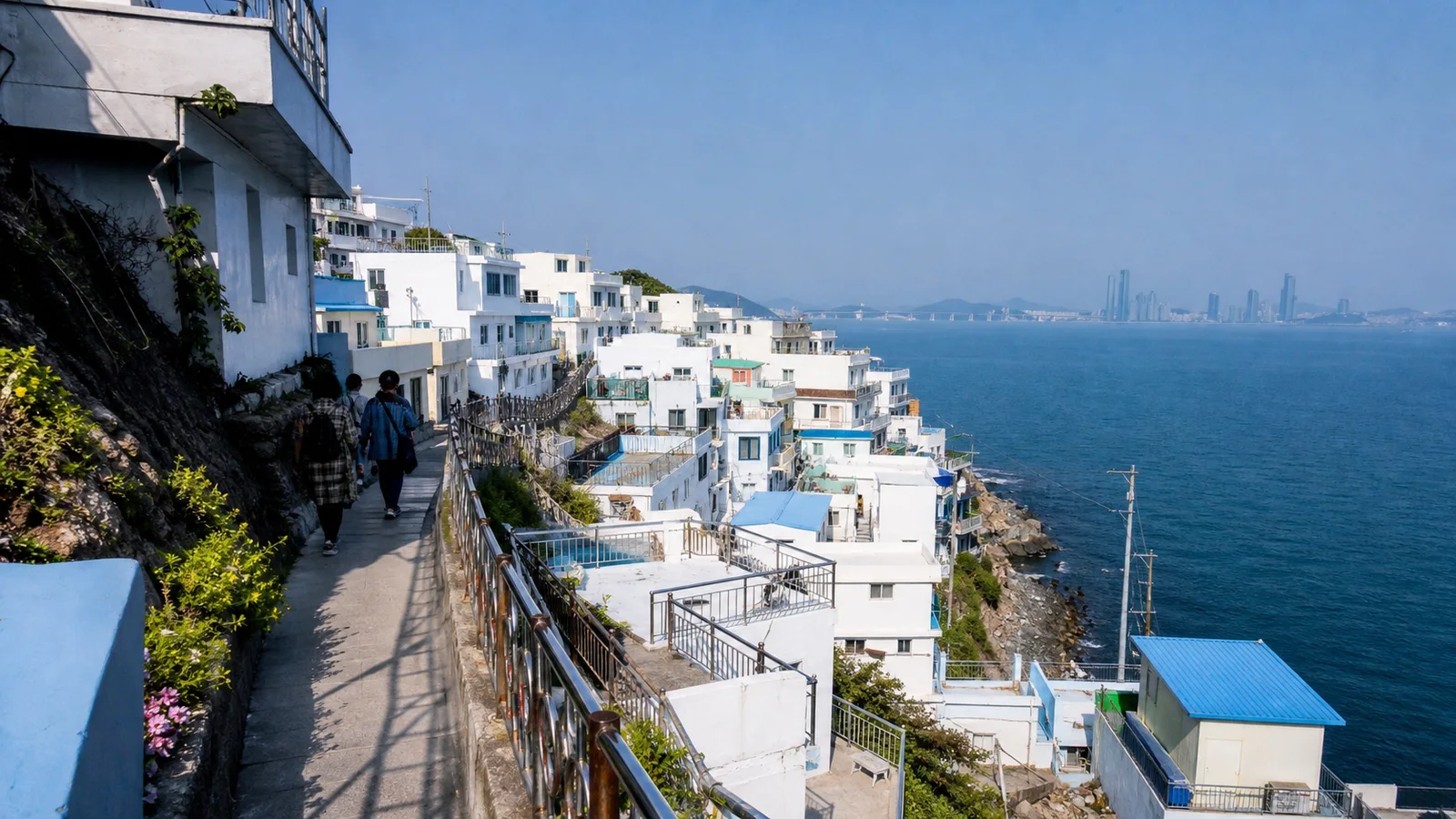 흰 건물과 좁은 산책길 너머로 푸른 바다가 펼쳐진 부산 흰여울문화마을