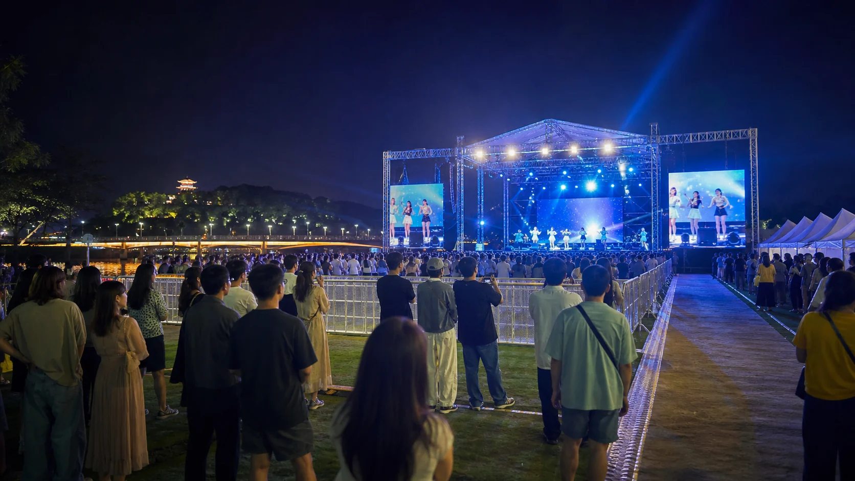 공주 금강변 여름 축제의 야간 공연을 안전선 뒤에서 관람하는 방문객