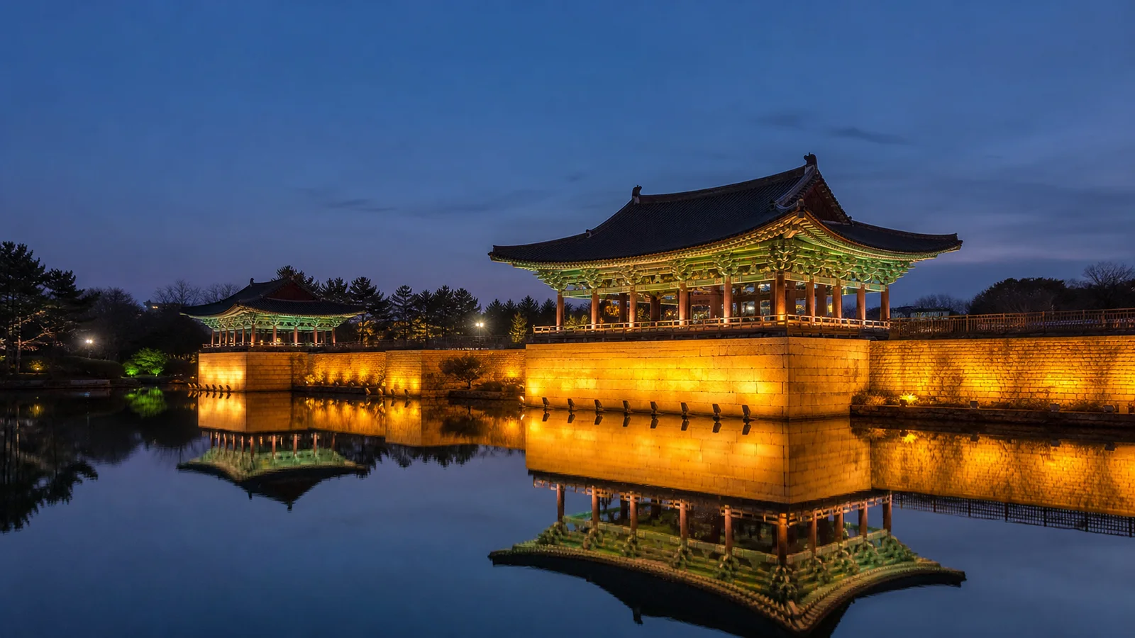 조명이 켜진 전통 누각이 연못에 비치는 경주 동궁과 월지의 저녁