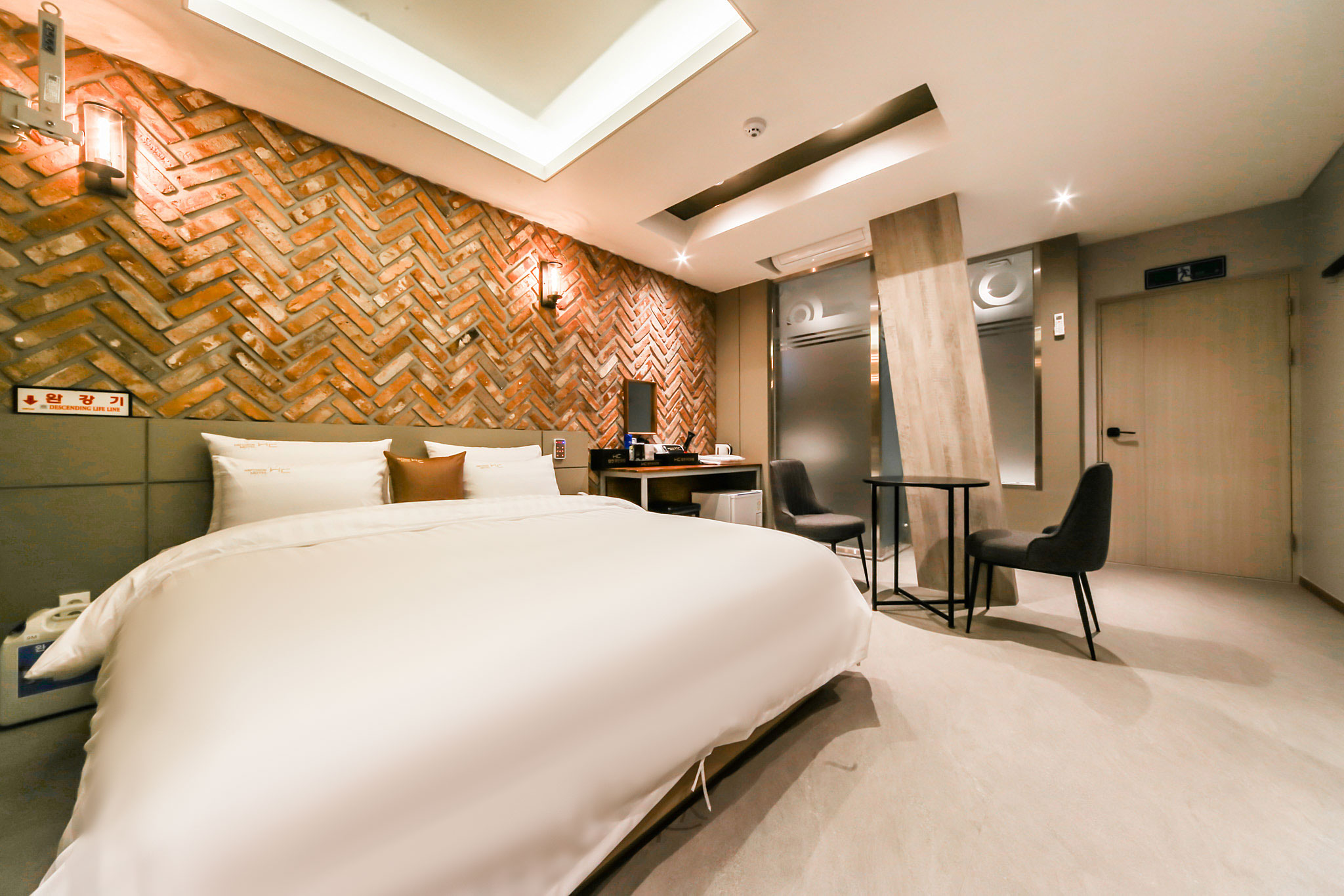 벽돌 무늬 벽과 더블 침대가 있는 합천 H.C. HOTEL 객실