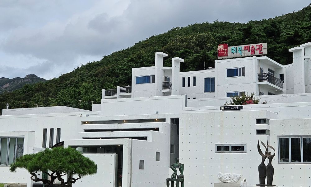 산 아래 자리한 휘목아트리조트 흰색 건물